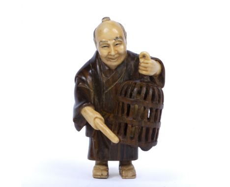 Boxwood and ivory netsuke Japanese, early 20th Century in the form of a figure holding a cage