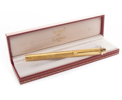 LES MUST DE CARTIER BALLPOINT PEN, gold coloured, the case with textured decoration, with silver coloured section to the top,