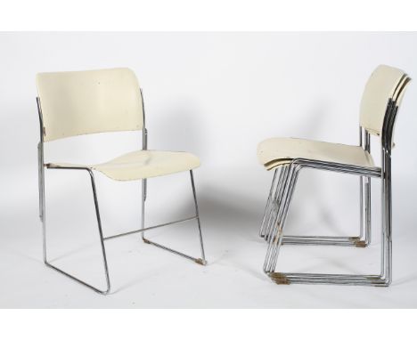 A set of four David Howe 20th Century vintage metal stacking chairs having white finished backrest and seat raised on chromed