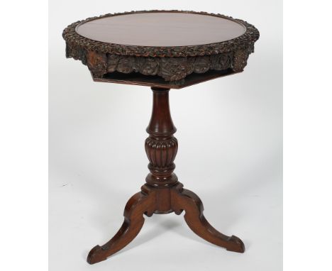 A Victorian mahogany lazy Susan occasional table, the revolving circular top with carved oak leaf and acorns rim above a shel