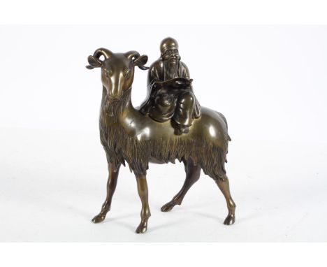 A Chinese bronze censer, late 19th or 20th century, modelled as an immortal reading a scroll seated on a goat, 25cm high x 20