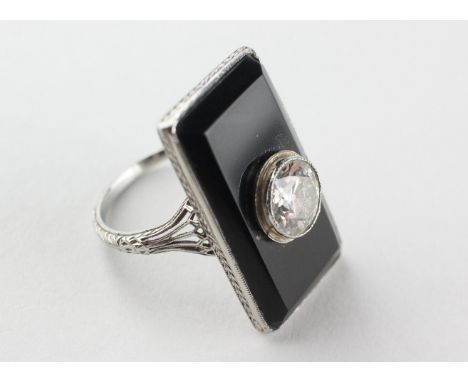 A white metal onyx panel ring centrally set with a transitional cut diamond estimated to weigh 1.15cts. Colour: I/J Clarity: 