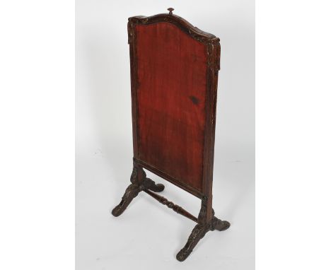A Victorian stained oak rise and fall fire screen, late 19th century, with red upholstered screen within foliate carved frame