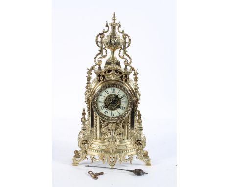 A French brass mantel clock, the ivorine dial on a brass eight day movement, striking to a bell, the case surmounted by an ur