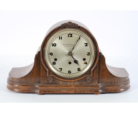 An oak mantel clock, the silvered dial inscribed Camerer, Cuss and Co, London, on a brass three train movement, chiming to ba