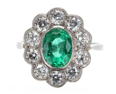 Large and impressive 18k white gold emerald and diamond oval cluster ring, the emerald 1.40ct approx, in a surround of ten ro