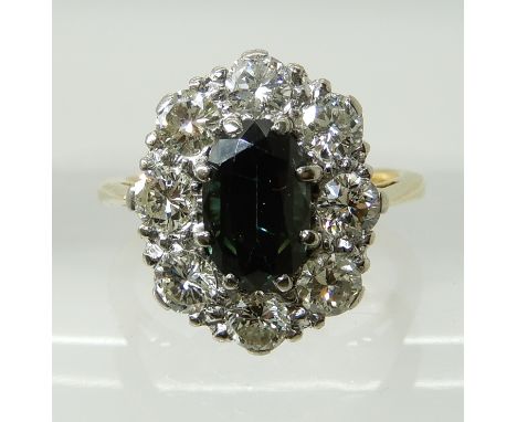 AN 18CT GOLD SAPPHIRE AND DIAMOND CLUSTER RING the central sapphire measures 8.4mm x 5.3mm x 4.1mm, surrounded with a halo of