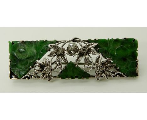 A CHINESE GREEN HARDSTONE AND DIAMOND BROOCH made in white metal throughout, with flower carved panels, and rose cut diamonds