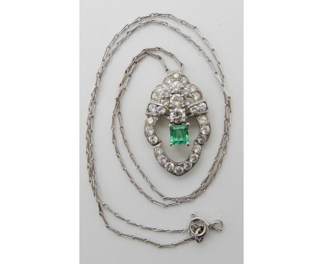 A WHITE METAL DIAMOND AND EMERALD PENDANT set with a step cut emerald approx dimensions 4.5mm x 4.9mm x 3.1mm, and further se