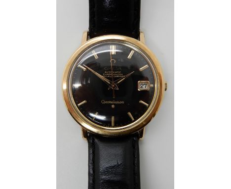 A GOLD PLATED OMEGA AUTOMATIC CONSTELLATION WATCH WITH BLACK DIAL and gold coloured baton numerals and date aperture. With bl