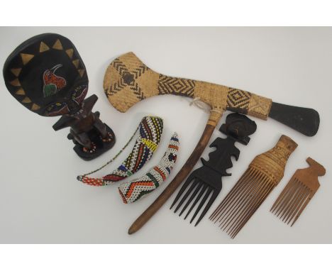 A GROUP OF AFRICAN TRIBAL ITEMS comprising; a Papua New Guinea ceremonial slate and wicker axe, 57cm wide, three hair combs, 