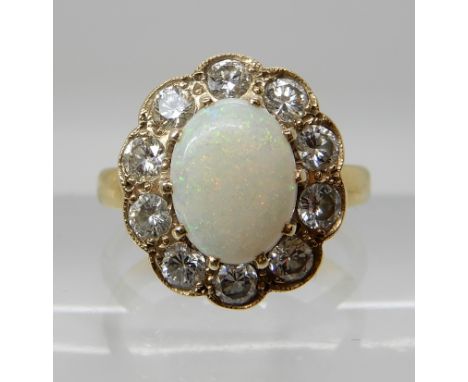 AN 18CT GOLD OPAL AND DIAMOND CLUSTER RING the white opal is approx 9.1mm x 6.8mm x 2.6mm, further set with a halo of brillia