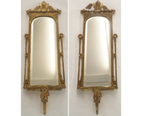 A PAIR OF 19TH CENTURY GILT WOOD AND GESSO WALL MIRRORS with foliate scroll surmounts above pillars joined to a serpentine sh