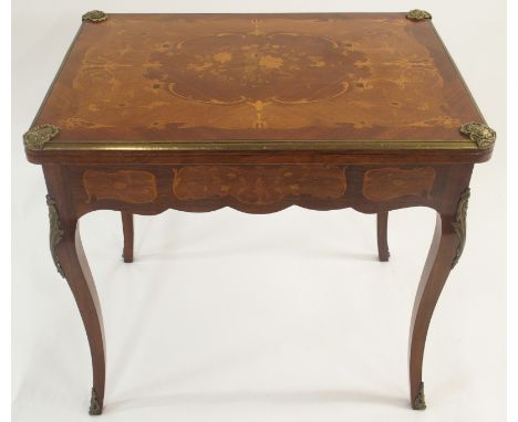 A FRENCH ROSEWOOD MARQUETRY GAMES TABLE the hinged top enclosing baize interior, the covers set with gilt metal shell mounts 