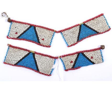 A Zulu/Nguni Beadwork Necklace, made up of four rectangular panels of turquoise triangles on a white field with red borders a