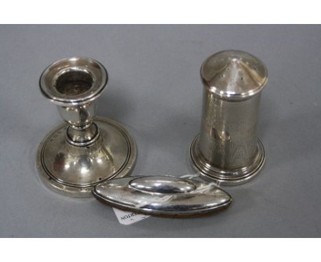 A SILVER CANDLESTICK, nail buffer and pepper pot (3)