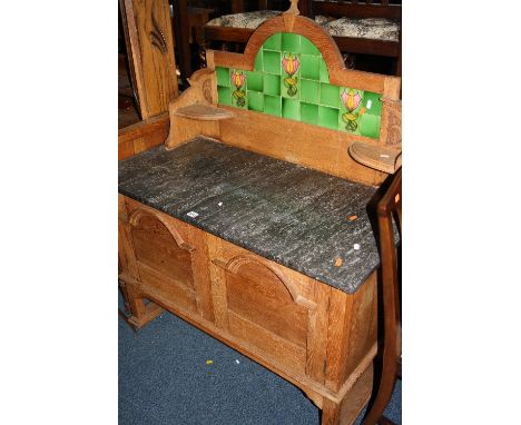 AN OAK WASHSTAND, with cupboard base, black marble top and tile back