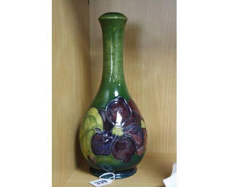 A MOORCROFT POTTERY LAMP BASE, 'Clematis' pattern on green ground, impressed marks to base, height approximately 27.5cm (no f