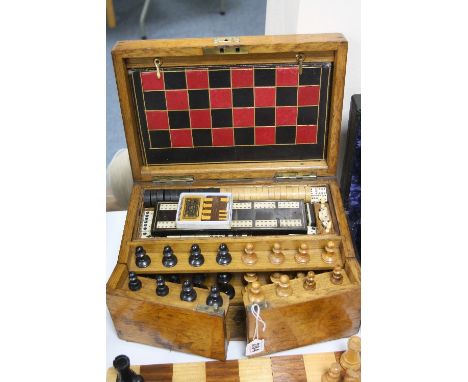 A LATE VICTORIAN OAK GAMES COMPENDIUM, the hinged top fitted with a four fold leather covered gaming board for chess, back ga