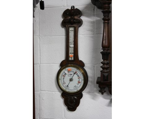 AN OAK ANEROID BAROMETER, painted oval mirror, another mirror and a collection of walking sticks