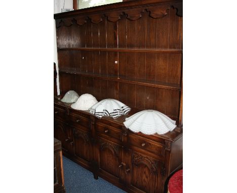 A LARGE OAK DRESSER, two shelf plate rack above four short drawers and four carved panelled doors, approximate size width 200