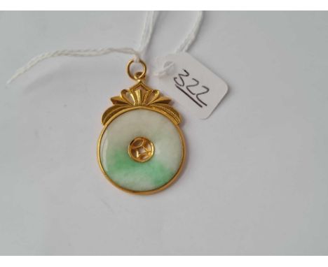 A circular jade pendant in high carat gold 