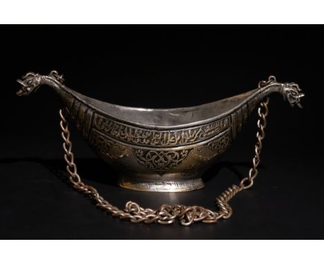 An Indian Deccan Brass Kashkul with Chain, 17th Century.This brass kashkul features curved sides tapering to pointed ends, ea