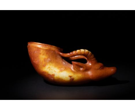 A Chinese Carved Jade Rhyton Cup with Ram's Head Handle.A carved Chinese jade rhyton cup featuring a warm, amber-toned jade w