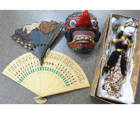 A Wayang Golek puppet doll, boxed and a Wayang Topeng comic mask plus two fans 