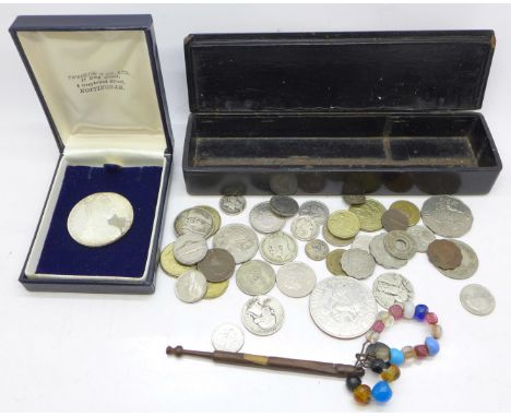 A Maria Theresia thaler and other coins and a lace bobbin with beads and a silver coin 