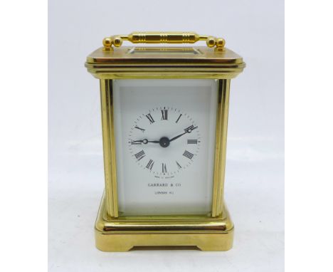 A small brass and glass carriage clock, the dial marked Garrard &amp; Co., London, with key 