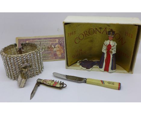 A Queen Elizabeth II Coronation figure, boxed, a British Armed Forces three pence note, knife and an Agent Provocateur bangle