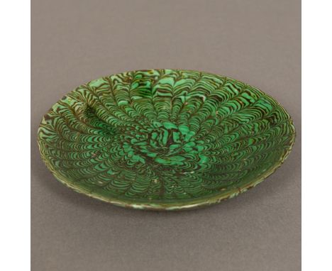 A Chinese Tang Dynasty pottery slip decorated peacock feather dishWith green glaze. 13.5 cm diameter.Provenance: From the lat