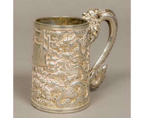 A late 19th/early 20th century Chinese silver tankardOf spreading cylindrical form with scrolling dragon handle, repousse dec