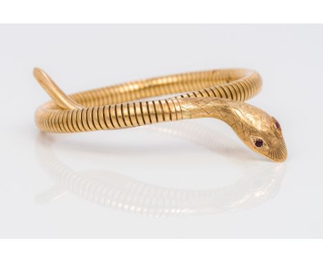 A 9 ct gold steel sprung bangle braceletModelled as a serpent with ruby set eyes. 