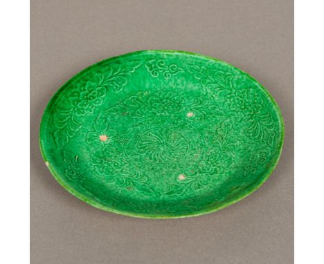 A Chinese pottery Liao Dynasty pottery dishWith moulded floral decoration on a green ground.  14 cm diameter. Provenance: Fro