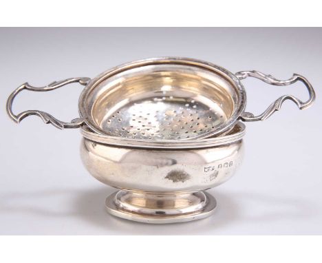 A GEORGE V SILVER TEA STRAINER AND STAND, by Mappin &amp; Webb Ltd, Birmingham 1919, the strainer with twin scroll-form handl