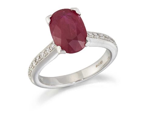 AN 18 CARAT WHITE GOLD RUBY AND DIAMOND RING, an oval-cut ruby to diamond-set shoulders. Estimated total diamond weight 0.25c