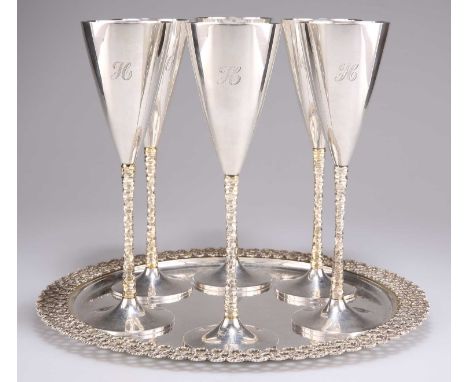 A SET OF SIX ELIZABETH II PARCEL-GILT SILVER CHAMPAGNE FLUTES ON TRAY, by Stuart Devlin, London 1977 (four flutes) and 1978 (