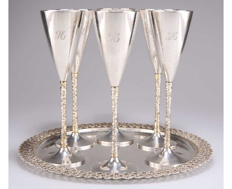 A SET OF SIX ELIZABETH II PARCEL-GILT SILVER CHAMPAGNE FLUTES ON TRAY, by Stuart Devlin, London 1977 (four flutes) and 1978 (