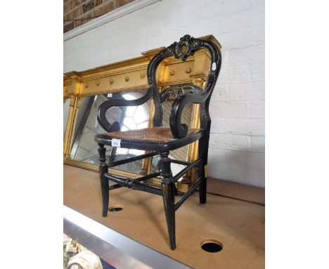 A VICTORIAN EBONISED AND GILT CHILD'S ARMCHAIR with cane seat and mother-of-pearl inlaid decoration