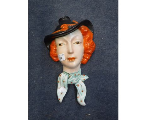 A CLARICE CLIFF STYLE ART DECO WALL MASK of a young lady with orange hair
