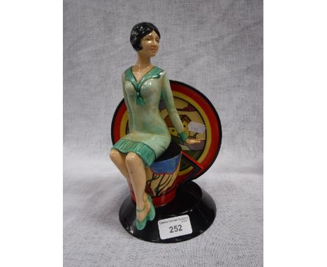A KEVIN FRANCIS YOUNG CLARICE CLIFF FIGURE with an Art Deco woman seated on a teacup by a saucer