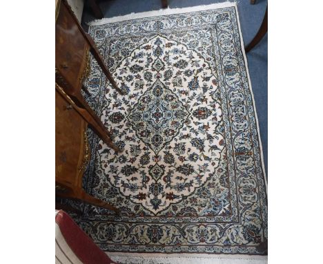 A CREAM GROUND PERSIAN DESIGN CARPET with floral design worked in blues and reds, 43" x 63"