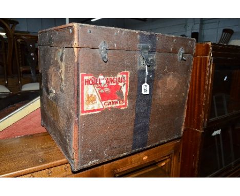 A VINTAGE CUBED TRUNK, showing various travel labels including Hotel Des Anglais, Cannes, Plymouth, Paris, etc, approximate s