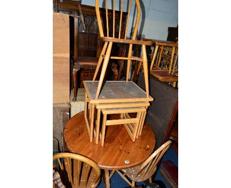 A SET OF THREE DISTRESSED BLONDE ERCOL STICK BACK CHAIRS, a pine circular kitchen table, an Edwardian elbow chair, and a nest