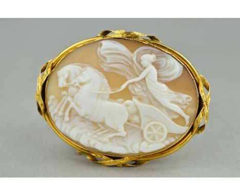 A LARGE OVAL SHELL CAMEO BROOCH, depicting a classical chariot scene, enclosed within a plain mount with engraved crossover s