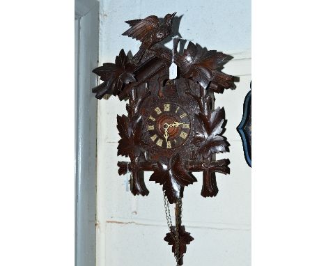 A LATE 19TH CENTURY OAK CUCKOO CLOCK, the sable with central bird flanked by leaves, the case similarly carved, circular dial