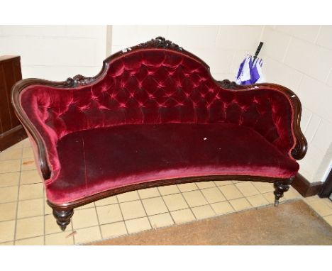 A VICTORIAN MAHOGANY SOFA, with a shaped back and floral fruiting vine, scrolled arms on turned baluster legs, brass caps and
