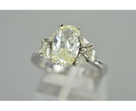 AN IMPRESSIVE DIAMOND DRESS RING, centring on a cushion cut diamond, measuring approximately 12.26mm x 7.56mm x 4.5mm, stated